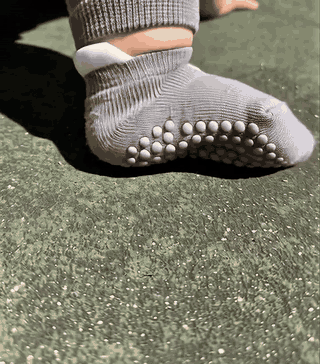 Close-up of Crawlies grip socks and knee sleeves during outdoor floor play