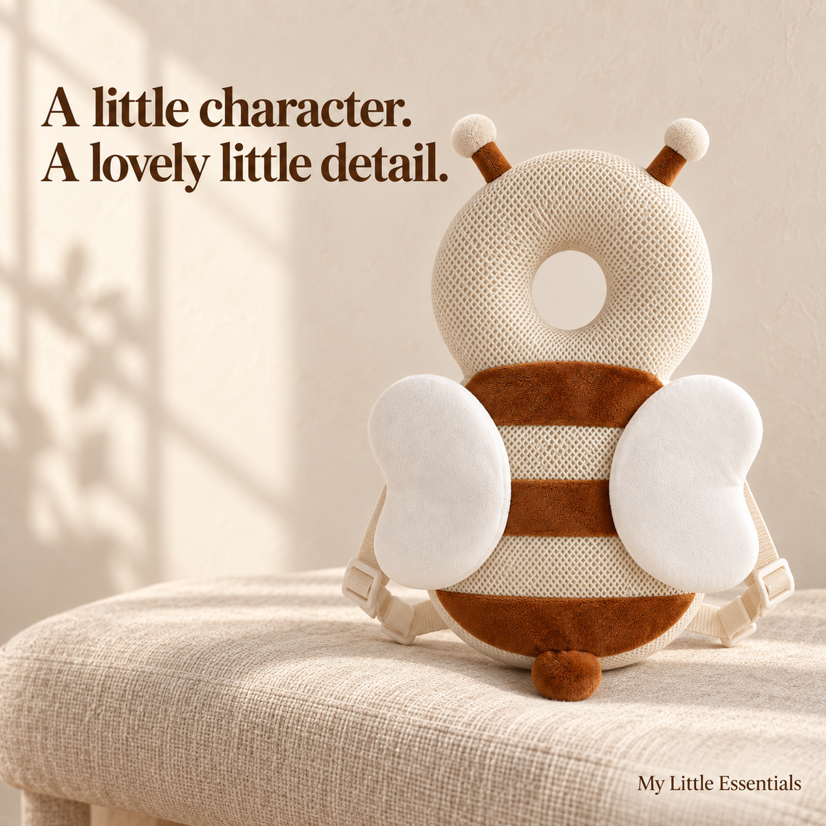 Ivory and cocoa bee cushion backpack displayed on an oat linen bench